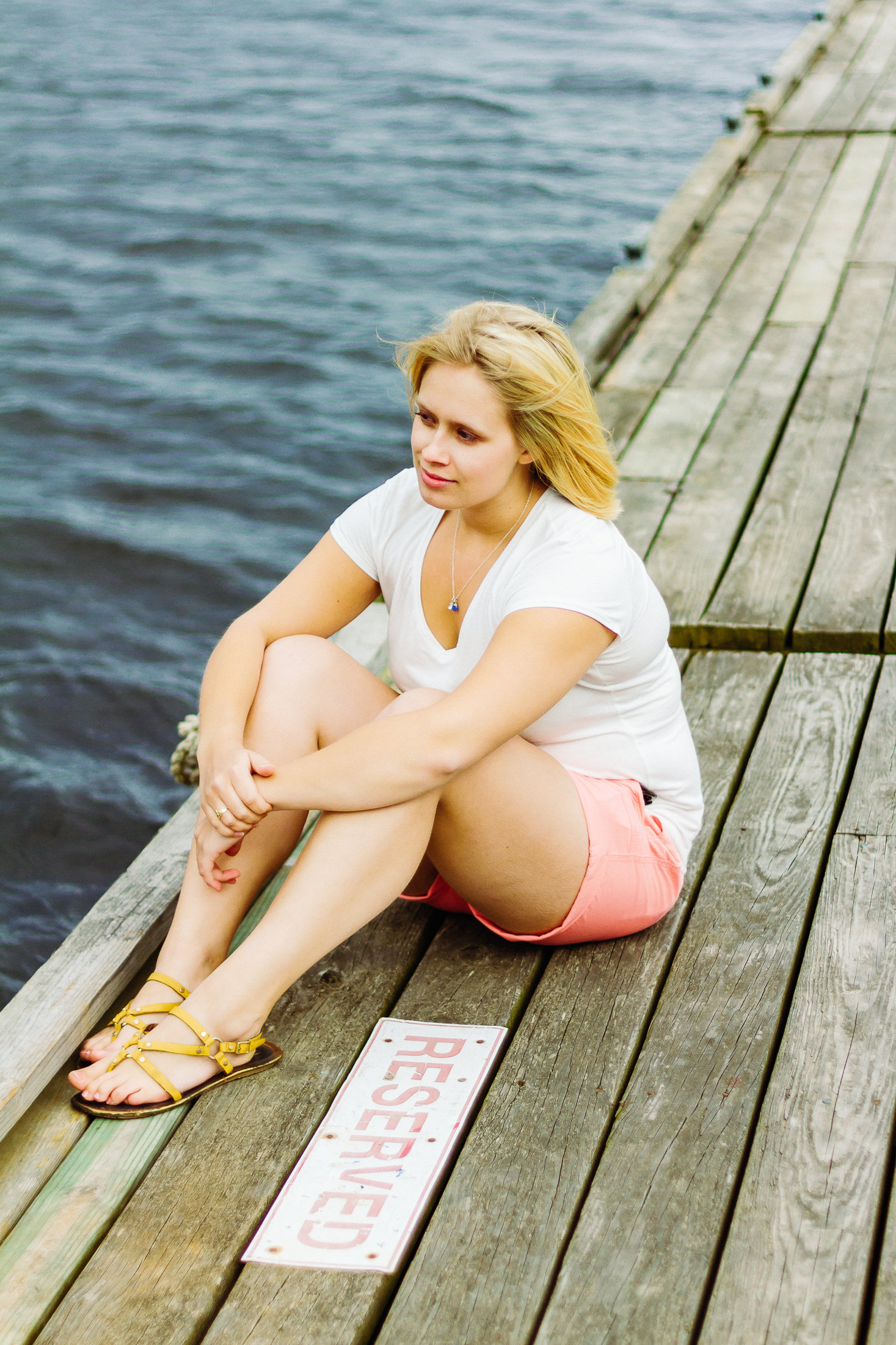 woman sitting on a dock during portraits in Belfast Maine