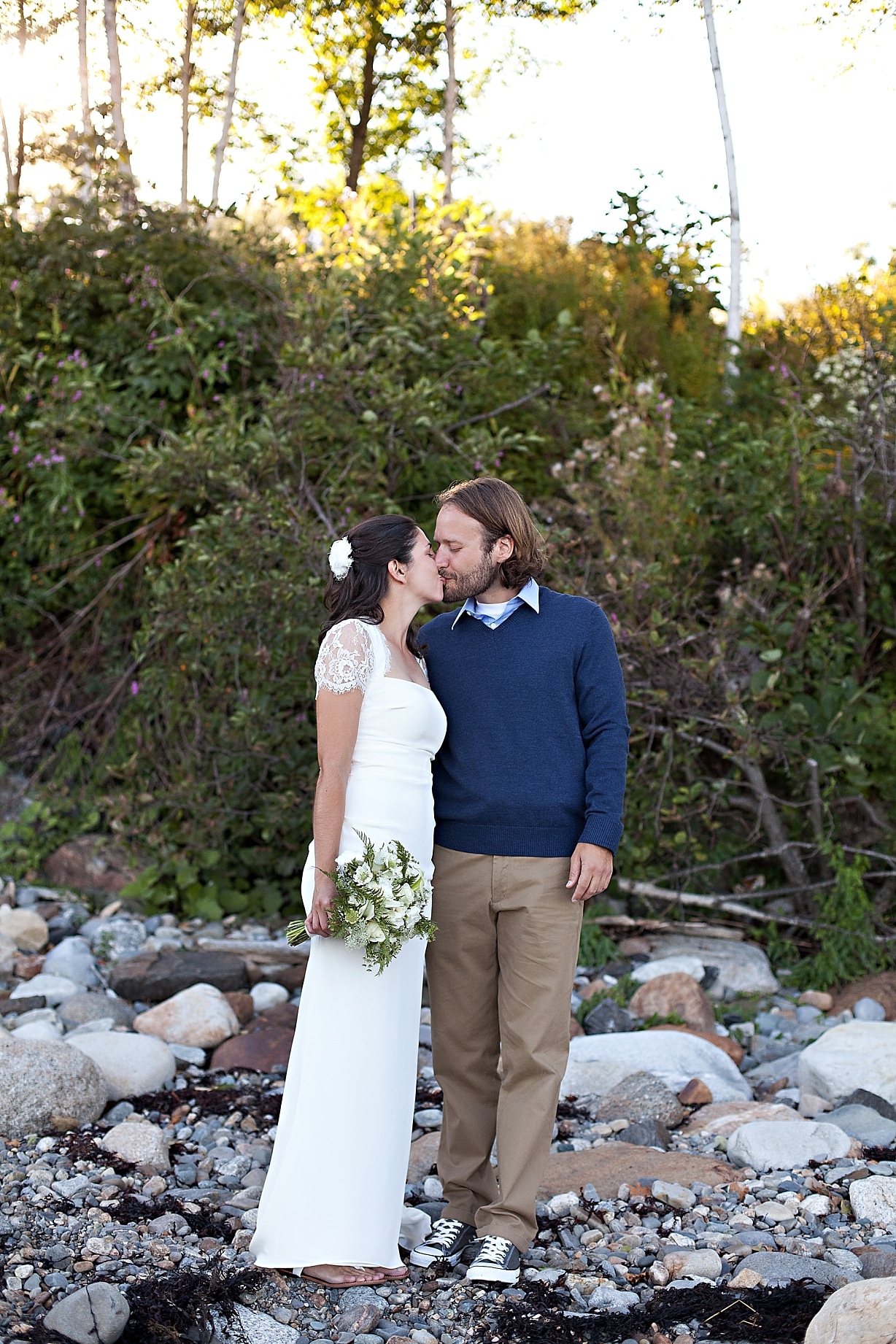 bride and groom kiss on beach at wedding at the Inn at Ocean's Edge