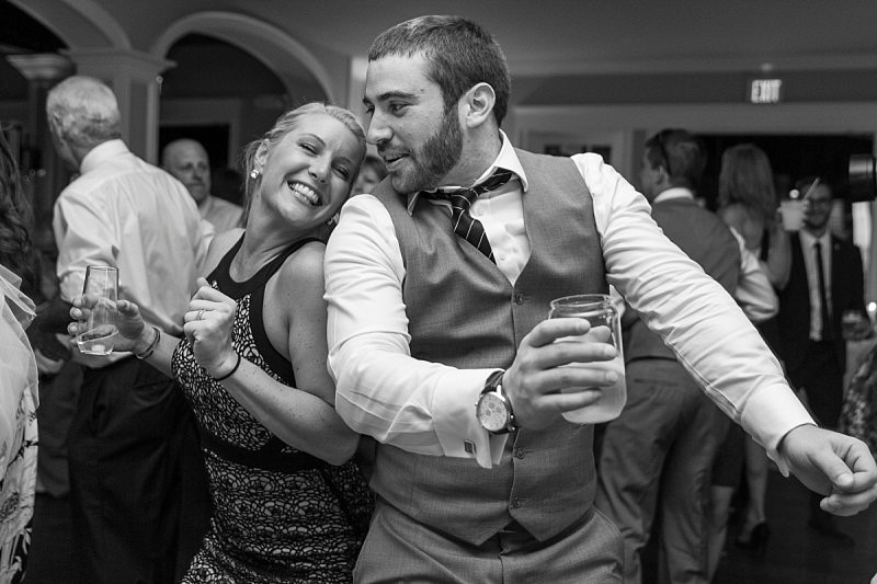A photo of wedding guests happily dancing back-to-back at a wedding.