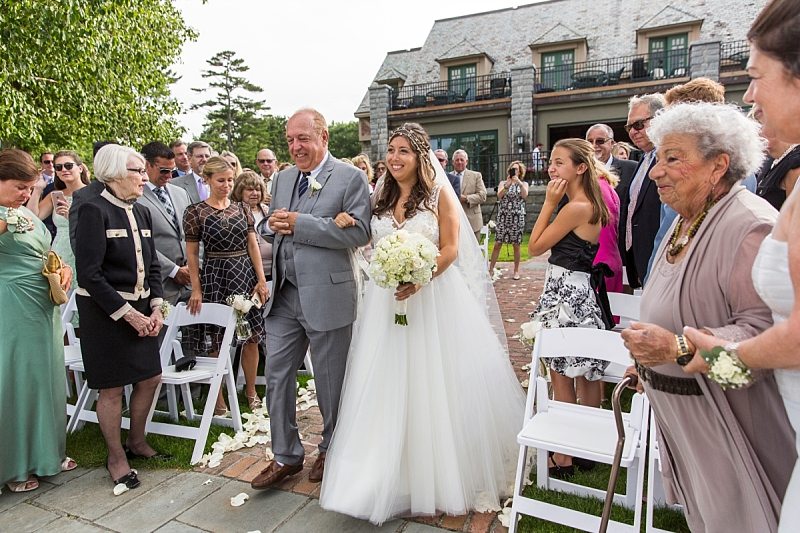 The bride and her father happily walk down the aisle for the wedding ceremony at The Regency in Bar Harbor, Maine.