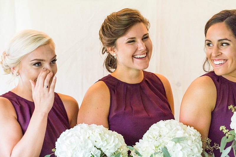 Three bridesmaids start laughing immediately after crying during the groom's vows at Flanagan Farm in Maine.