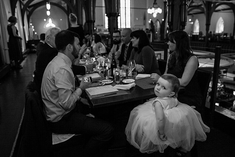 A flower girl looks unimpressed with the camera during the reception dinner.