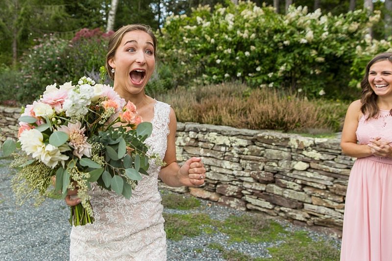 A bride screams in excitement when she sees someone at her wedding.