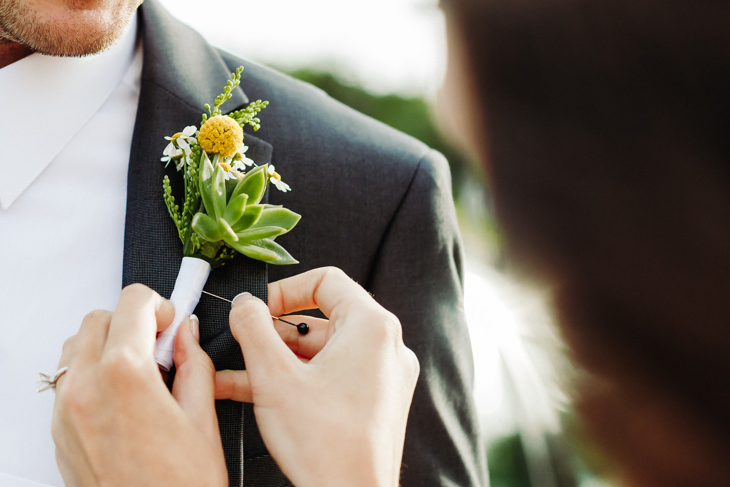 bride pins on groom's boutonniere at Seal Harbor Beach on MDI 