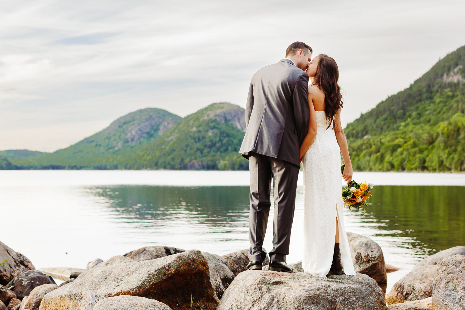 Bride and groom pose for a wedding portrait at Jordan Pond in Acadia National Park.