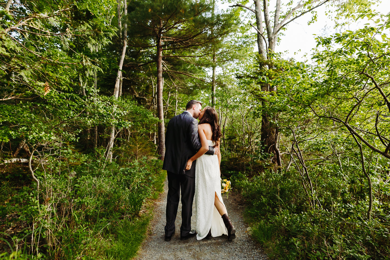 Bride and groom kissing in the woods after elopement at Jordan Pond in Acadia National Park
