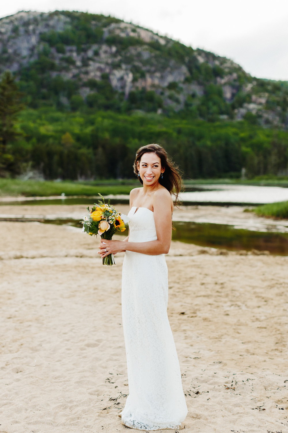 Bride with her bouquet at Sand Beach in Acadia National Park