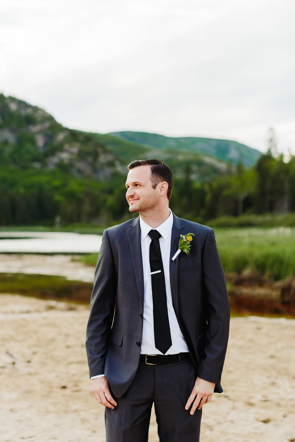 groom standing on Sand Beach in Acadia National Park