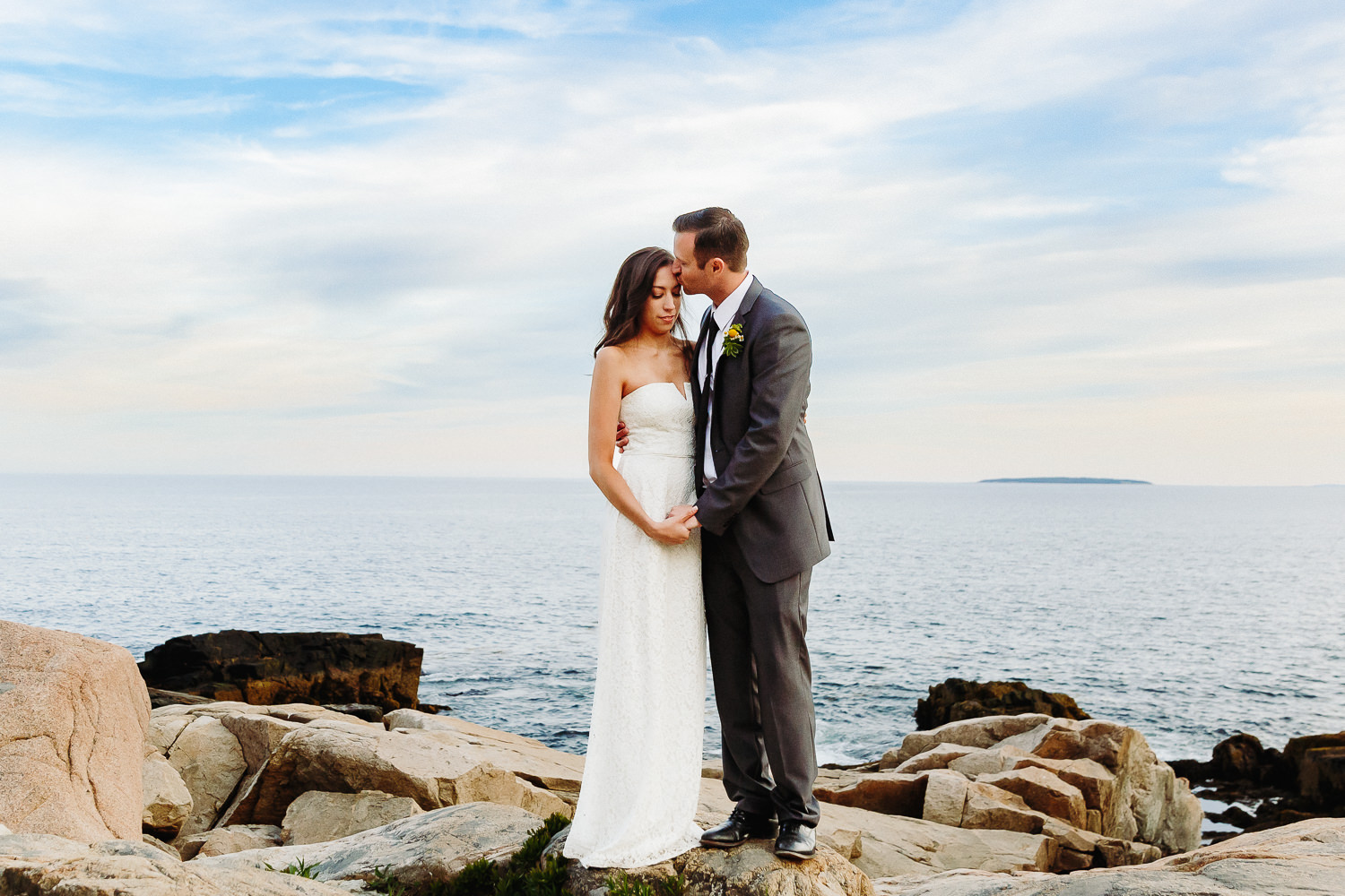 Groom kisses bride's forehead during Otter Point elopement in Acadia National Park