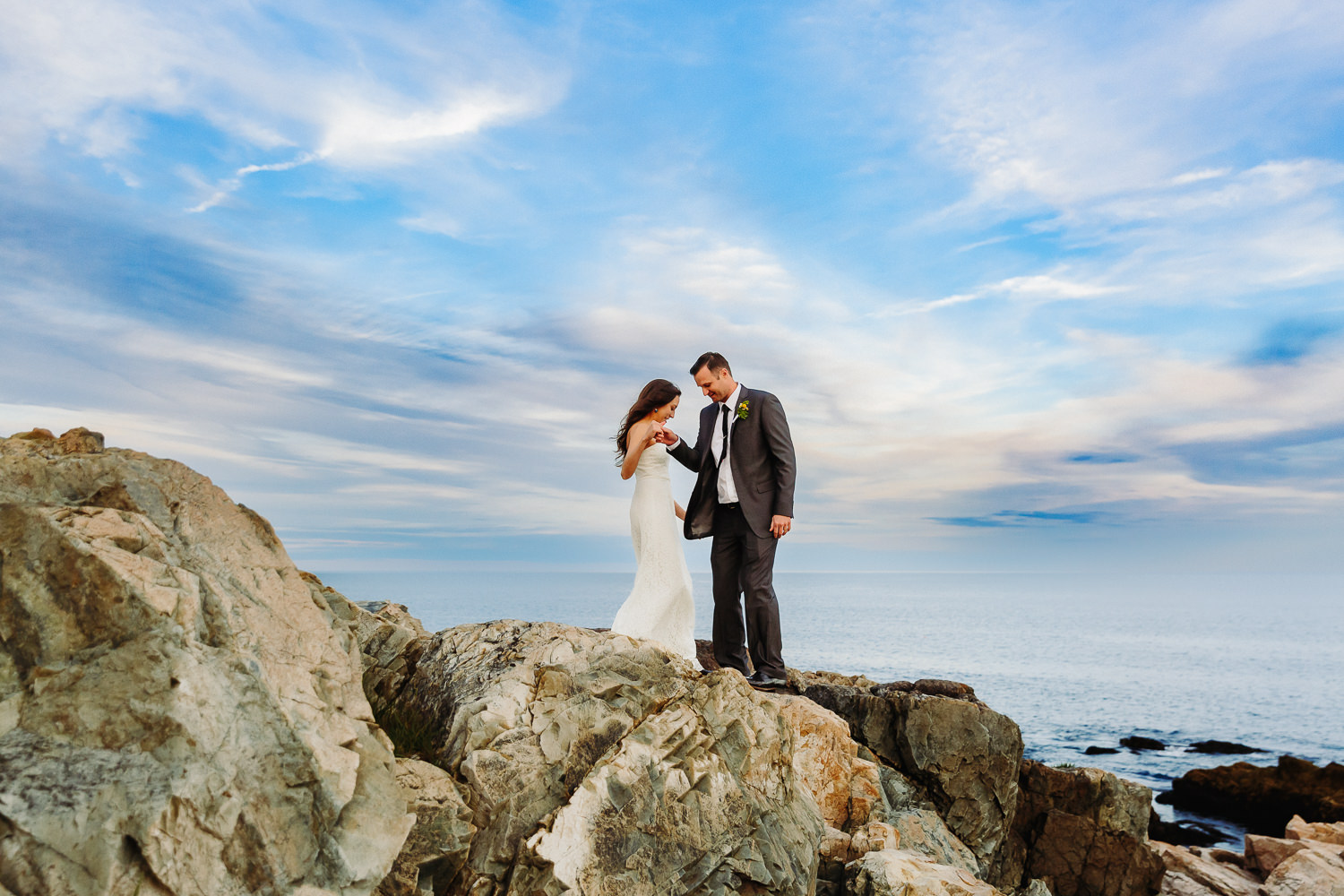 Bride and groom dance on cliffs at Otter Point in Acadia National Park.