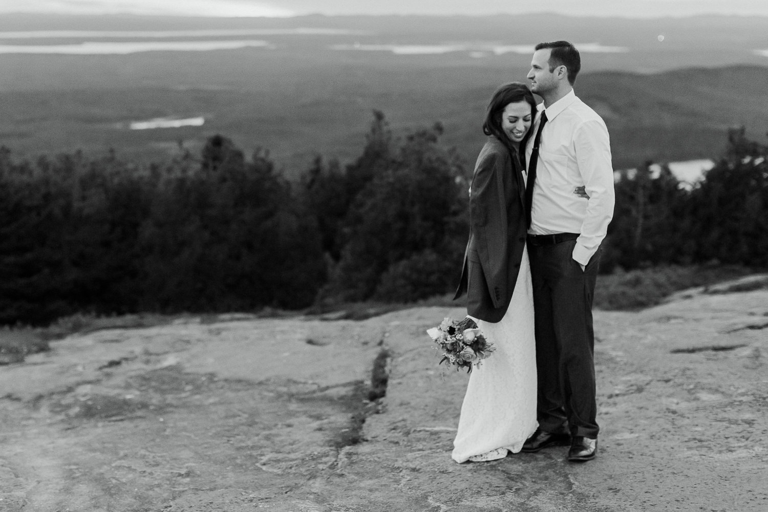 Bride and groom cuddling on Cadillac Mountain