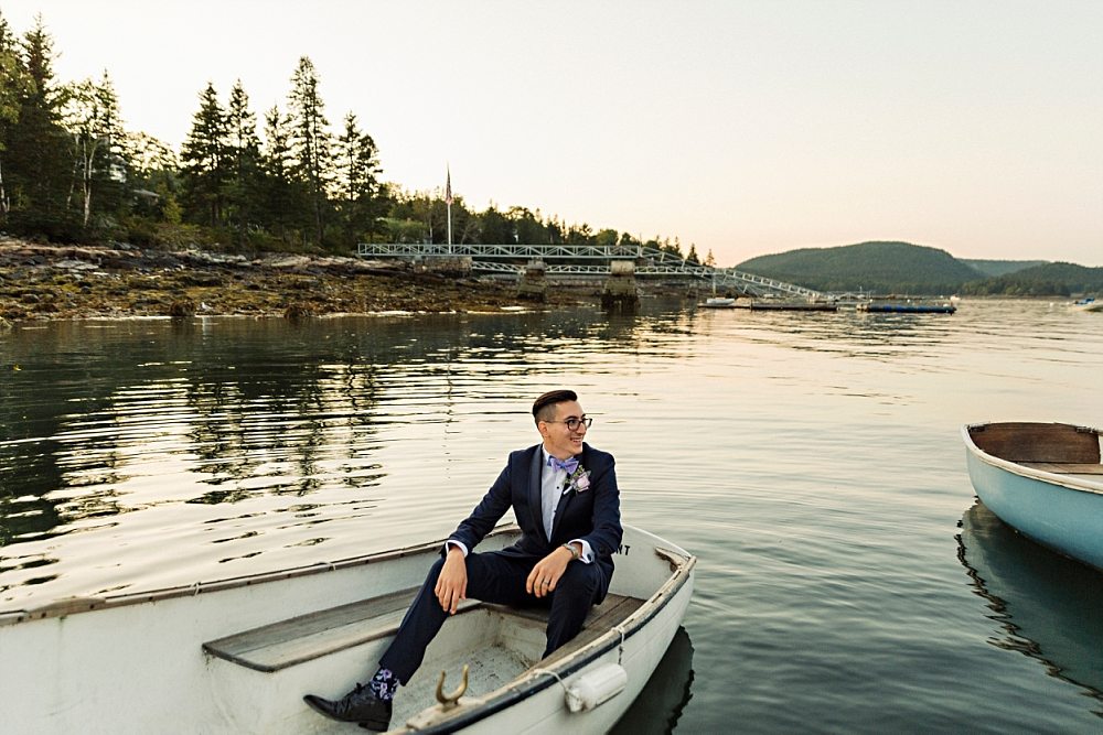 Groom sitting in a boat at Claremont Hotel Southwest Harbor wedding