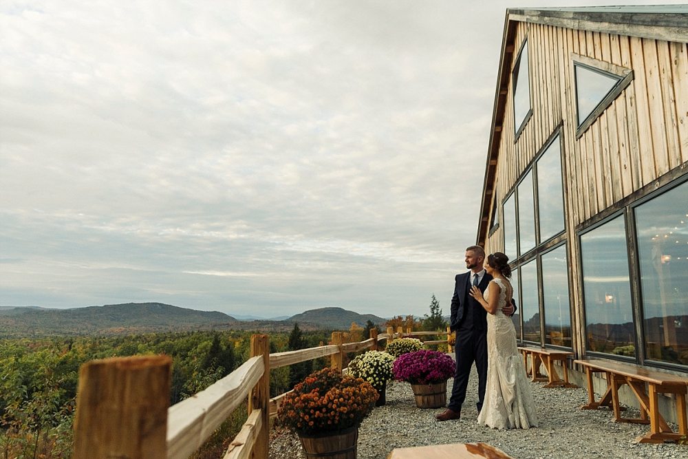 Bride and groom in front of barn at sunset during wedding at Granite Ridge Estate & Barn