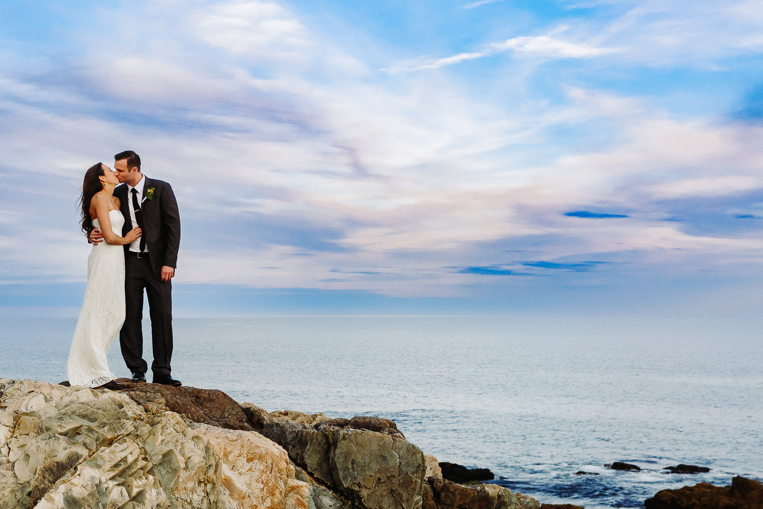 Bride and groom standing on cliffs at Otter Point during Acadia National Park elopement
