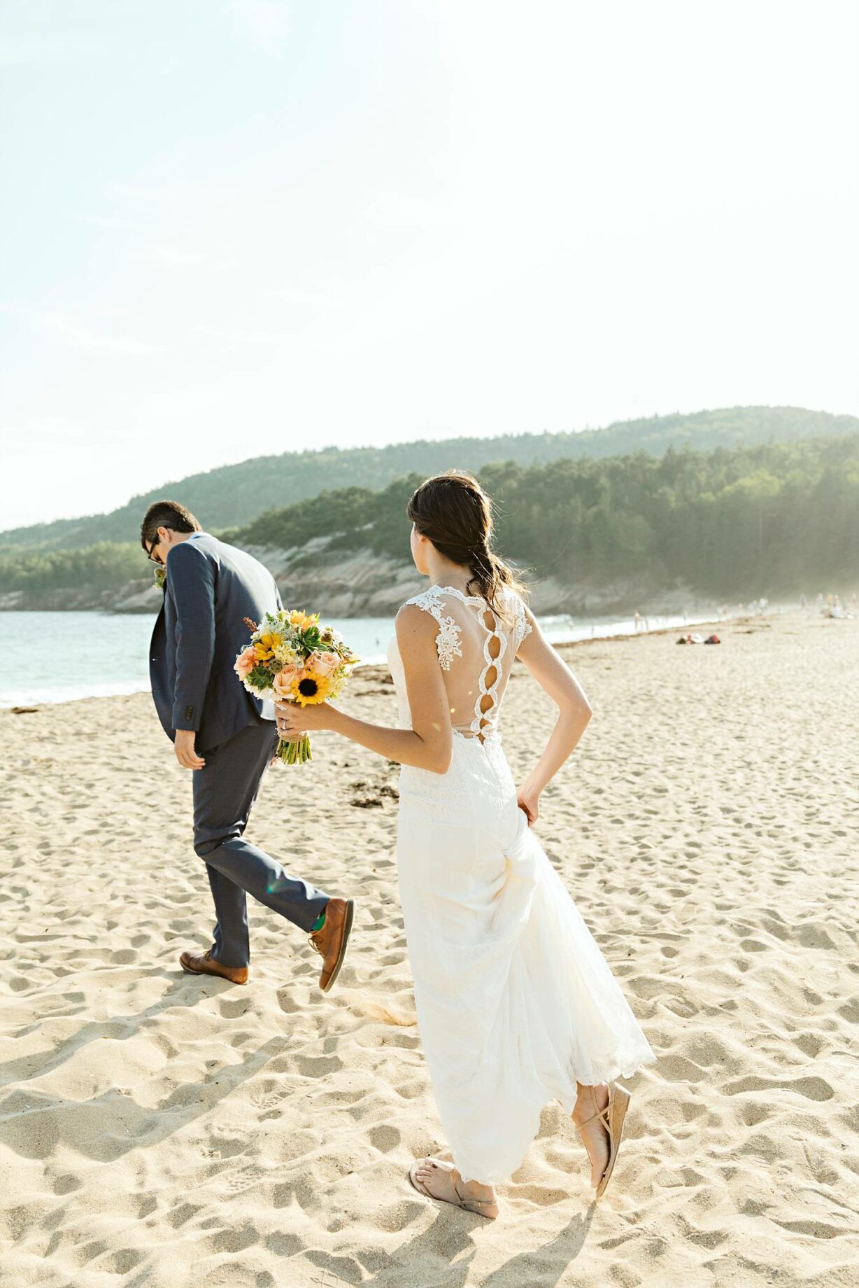 Bride and groom walking on the sand at Sand Beach Acadia elopement