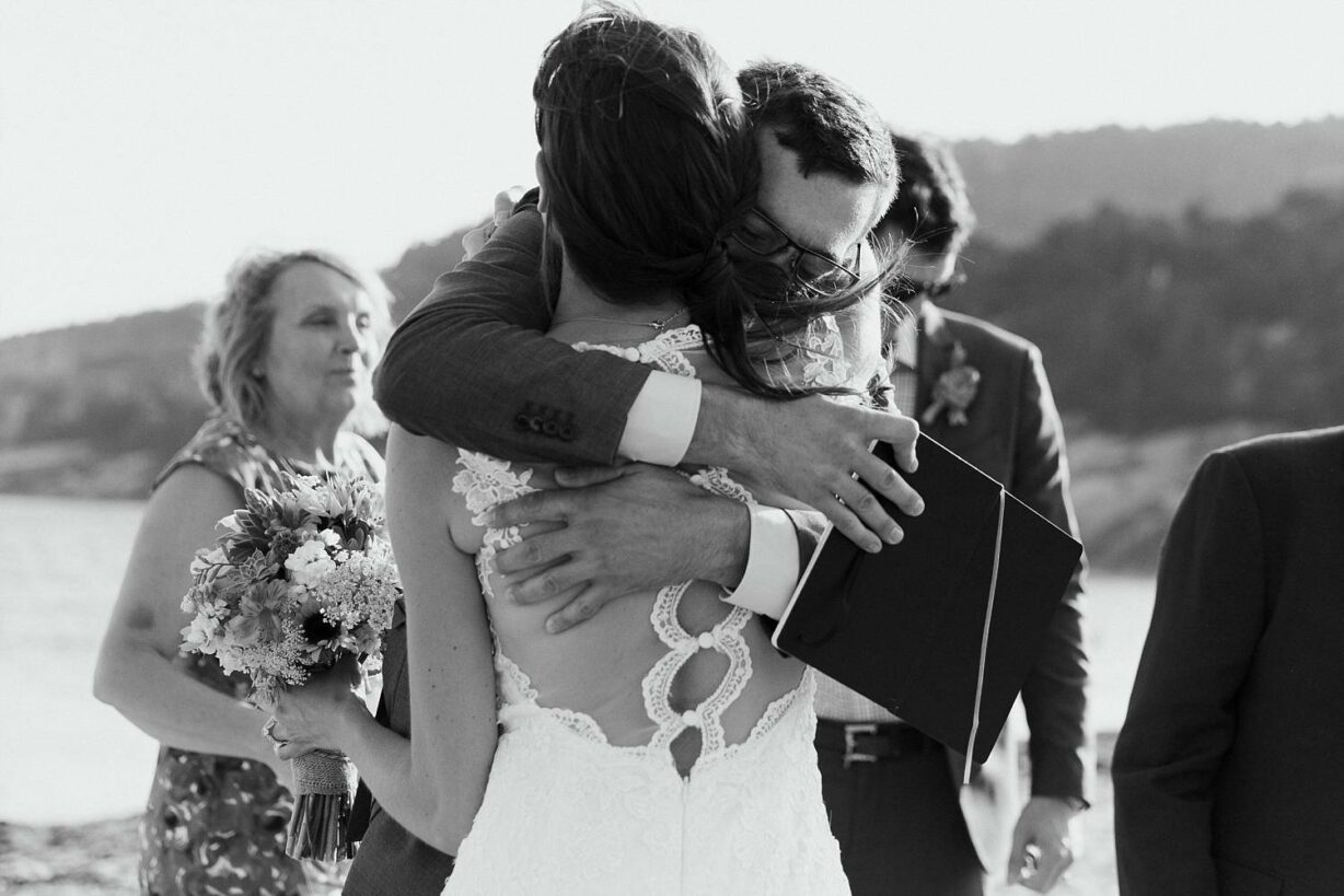 Bride hugging her brother after beach ceremony