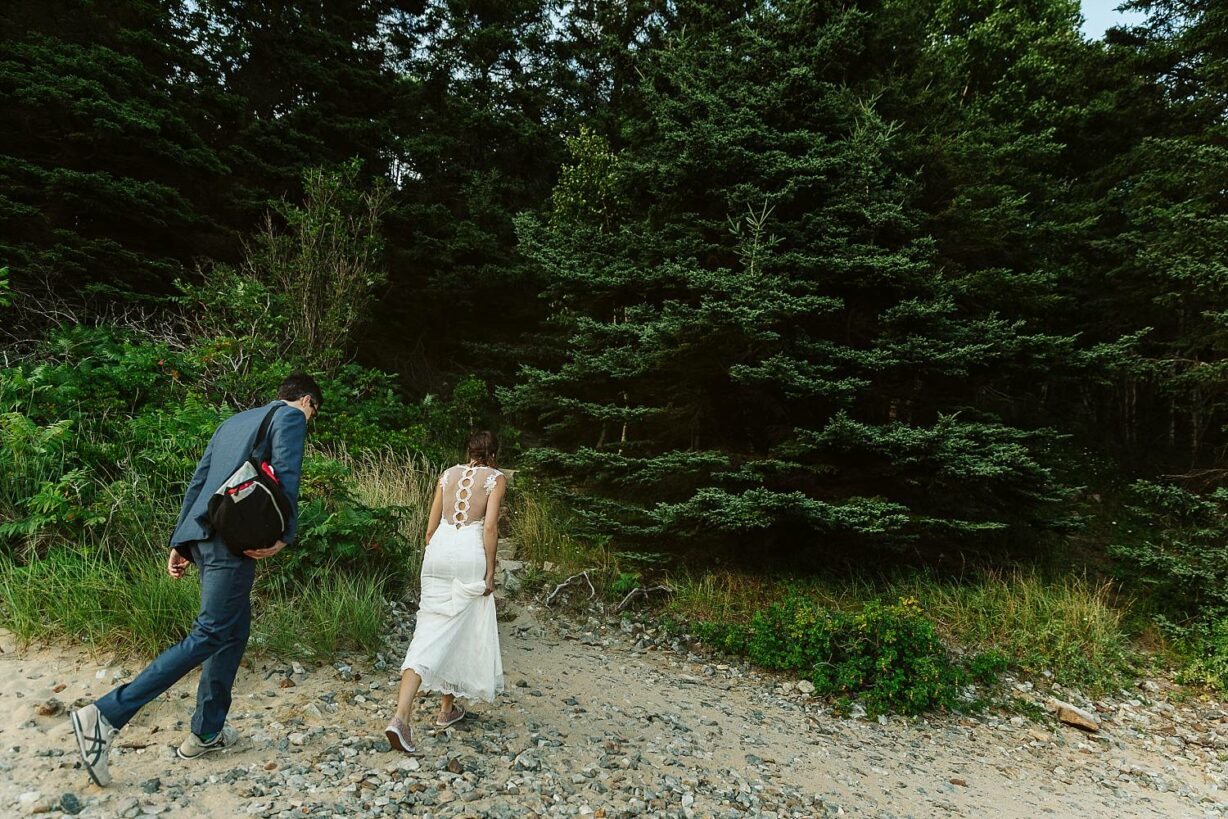 Bride and groom walking to hiking trail on Sand Beach