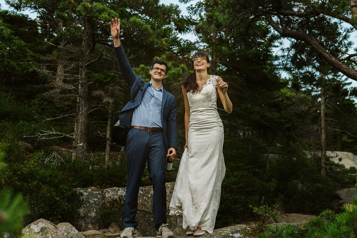 Bride and groom waving to their wedding guests from up high during Acadia elopement