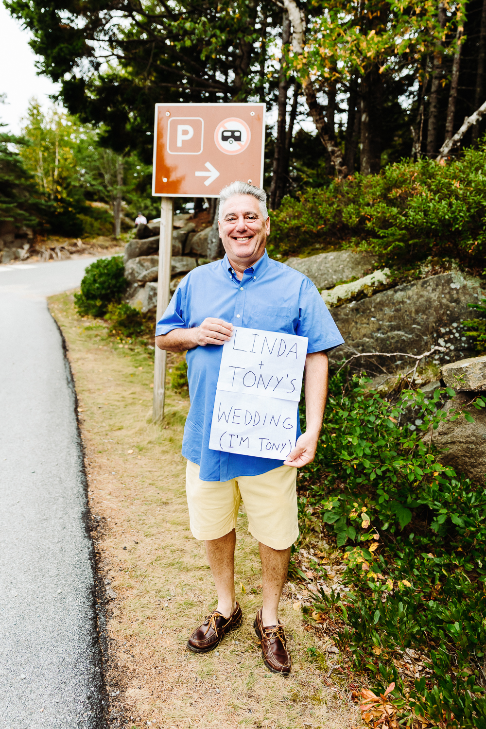 man holding sign at Otter Cliff Acadia elopement