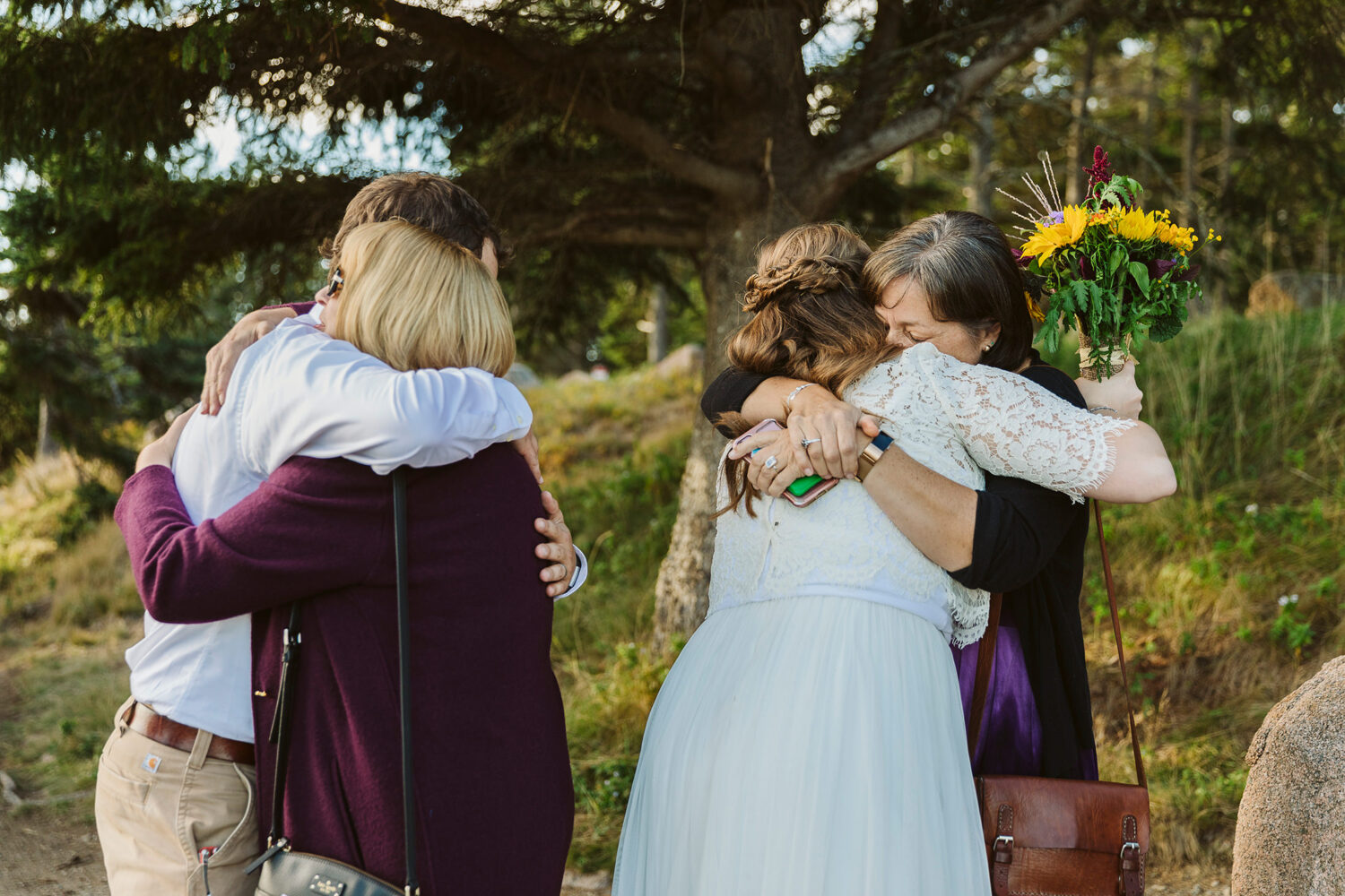bride and groom hugging wedding guests