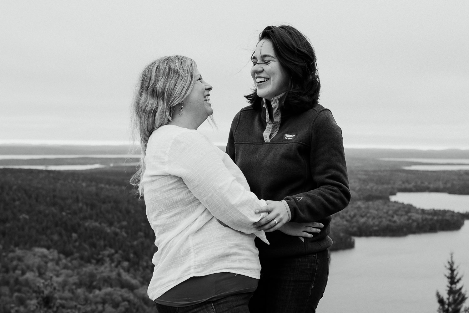 Two women laughing on mountain in Acadia National Park