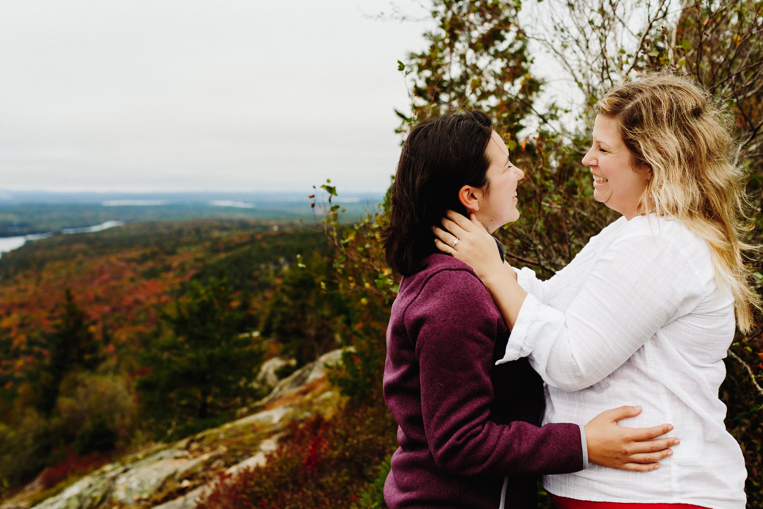 women embracing during engagement photos in Acadia National Park