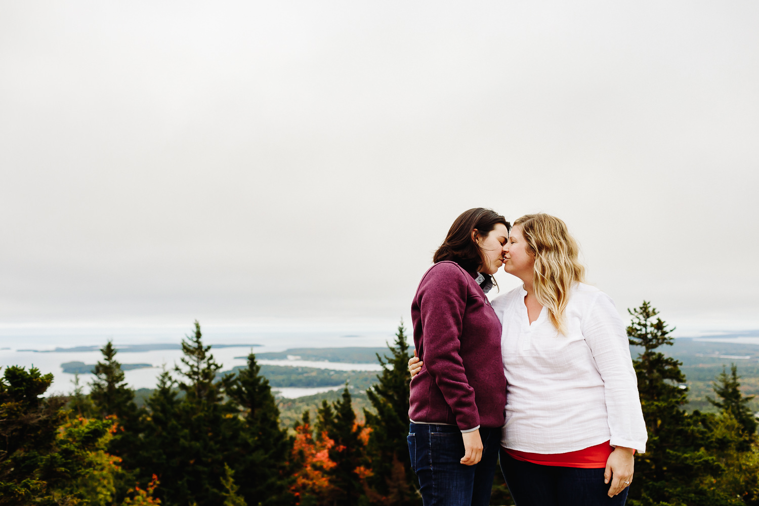 two women kissing together during engagement photos
