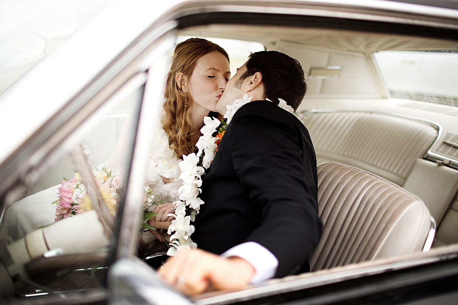 Bride and groom kiss in classic car at Bristol Maine wedding