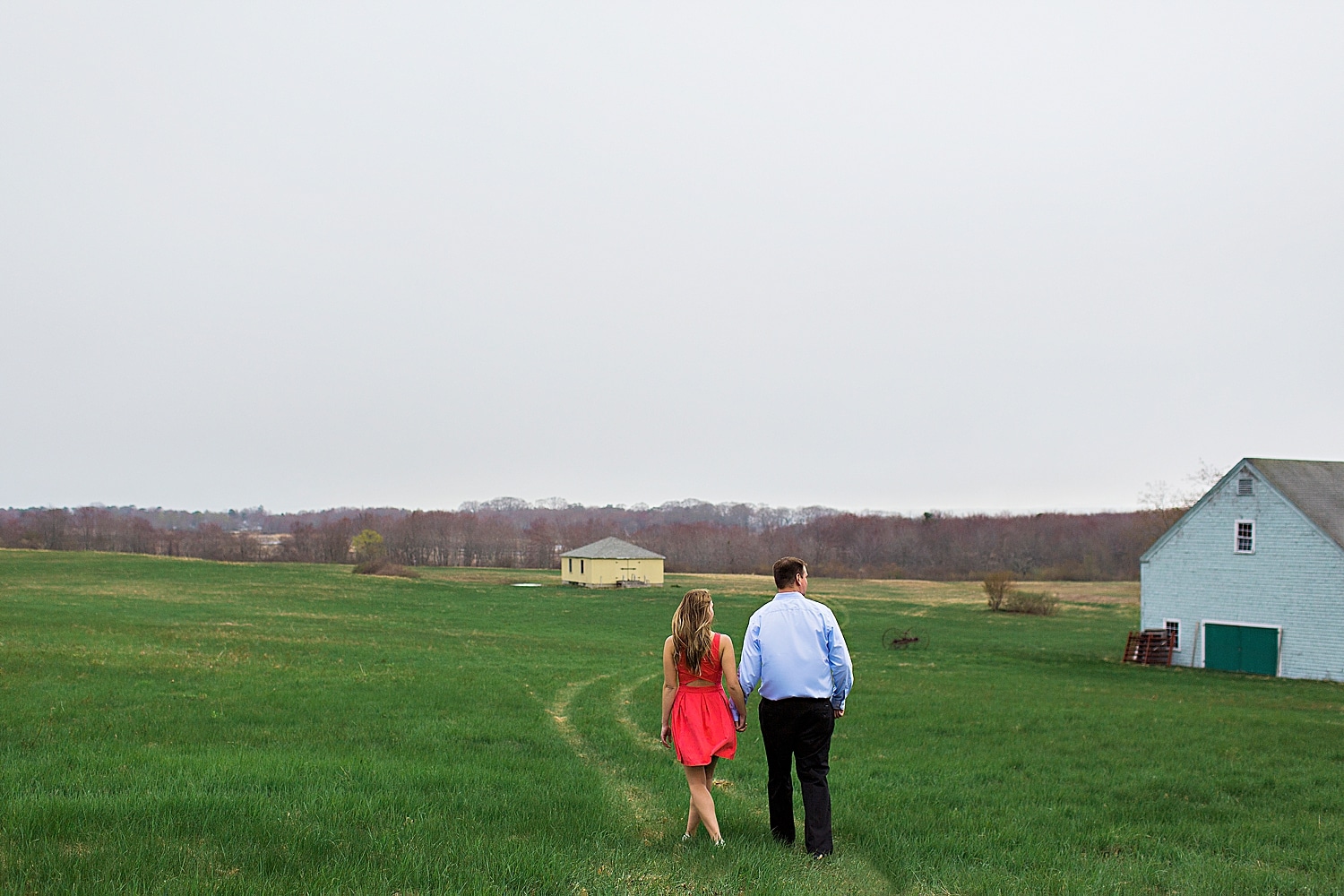 couple walking during engagement photos at The Wells Reserve at Laudholm