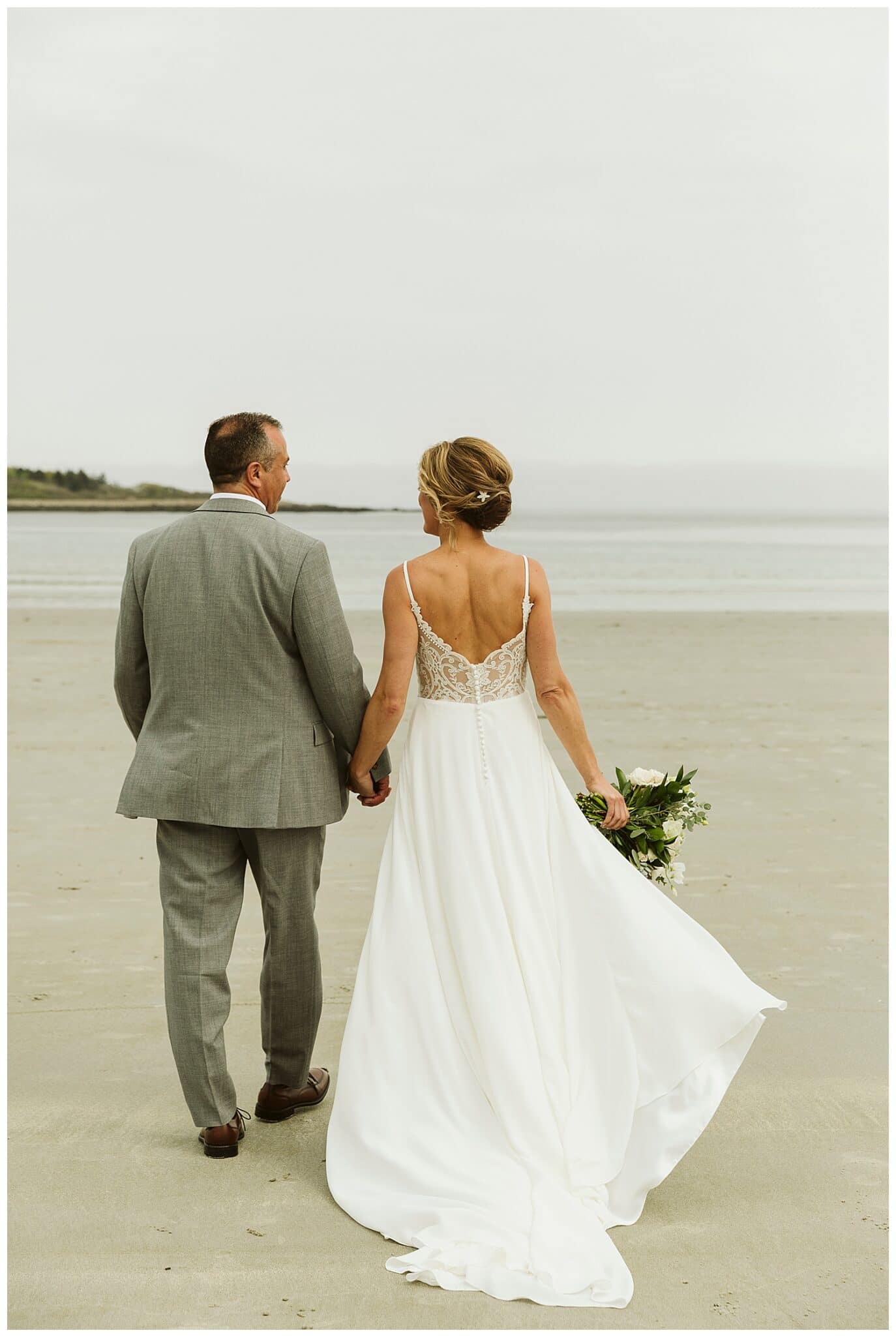 bride and groom walking on beach at Hidden Pond wedding in Kennebunkport, Maine