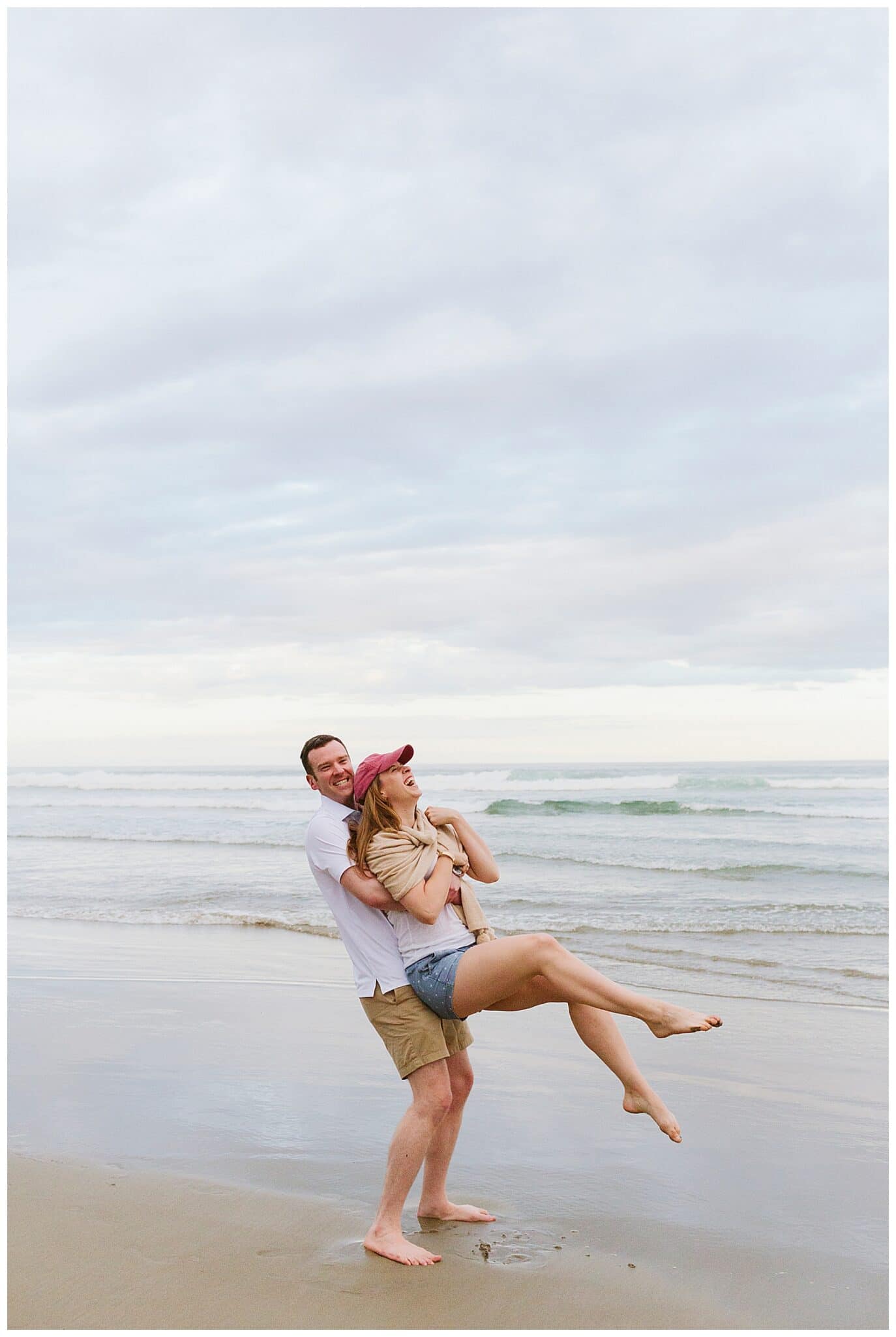groom-to-be swinging around his fiancee on Ogunquit Beach