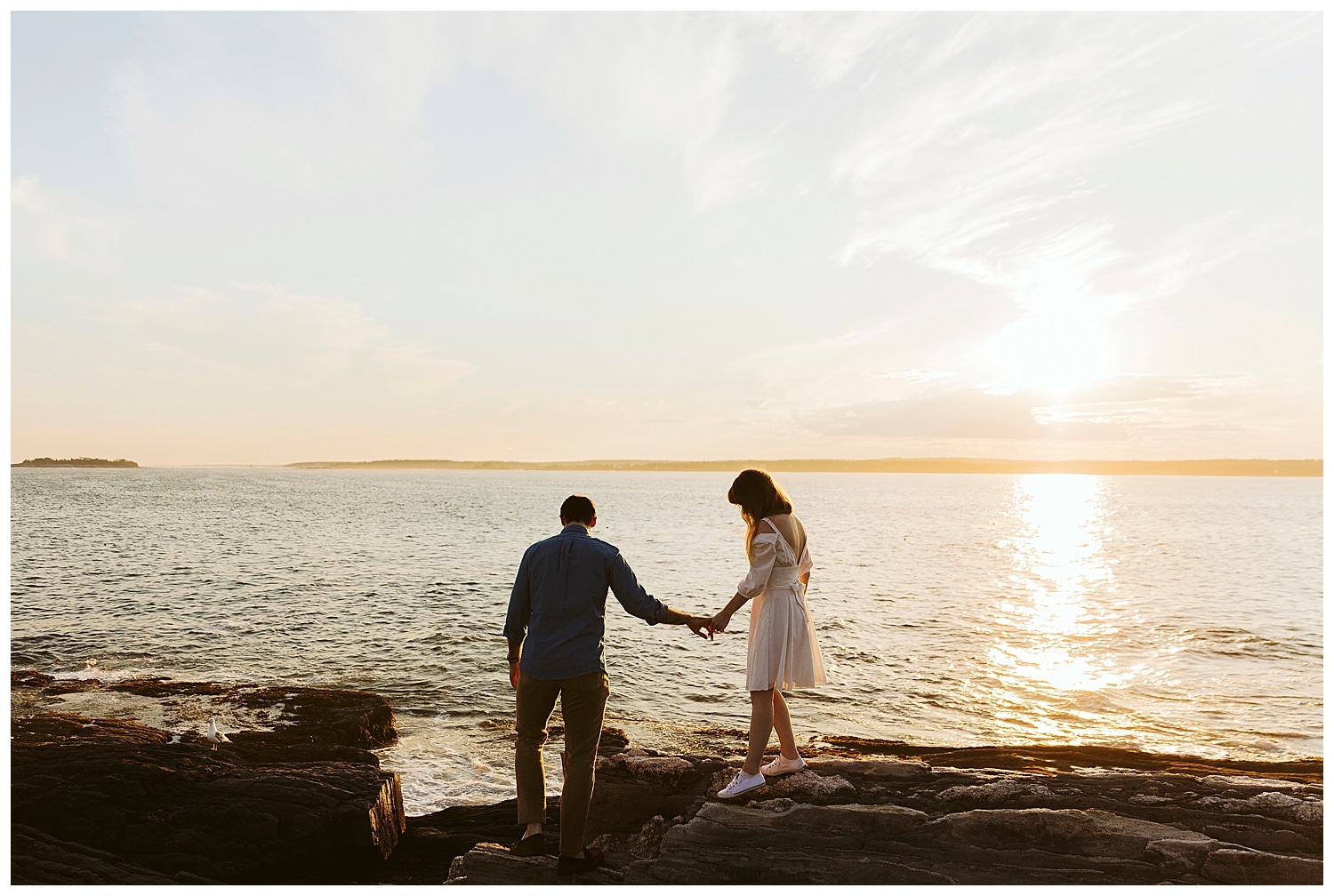 couple exploring cliffs during Engagement photos in Bristol Maine