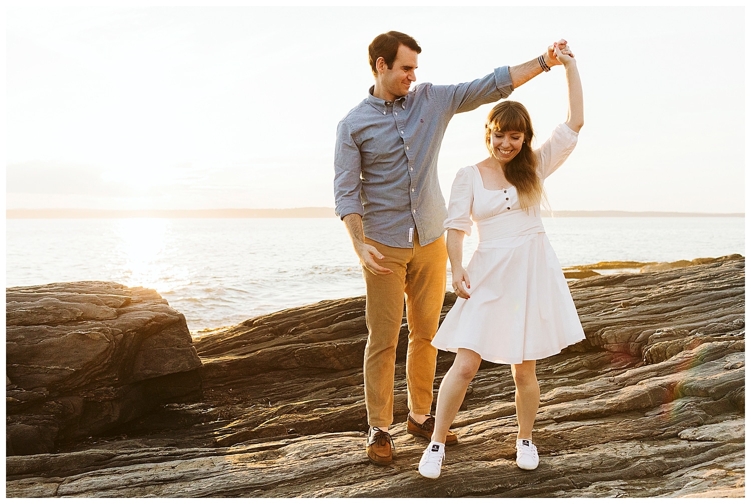 couple dancing on cliffs by ocean