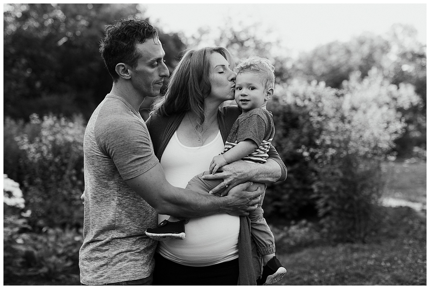 mom kissing toddler during maternity photos at University of Maine
