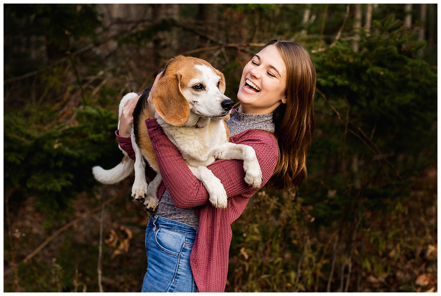 woman laughing while holding a beagle