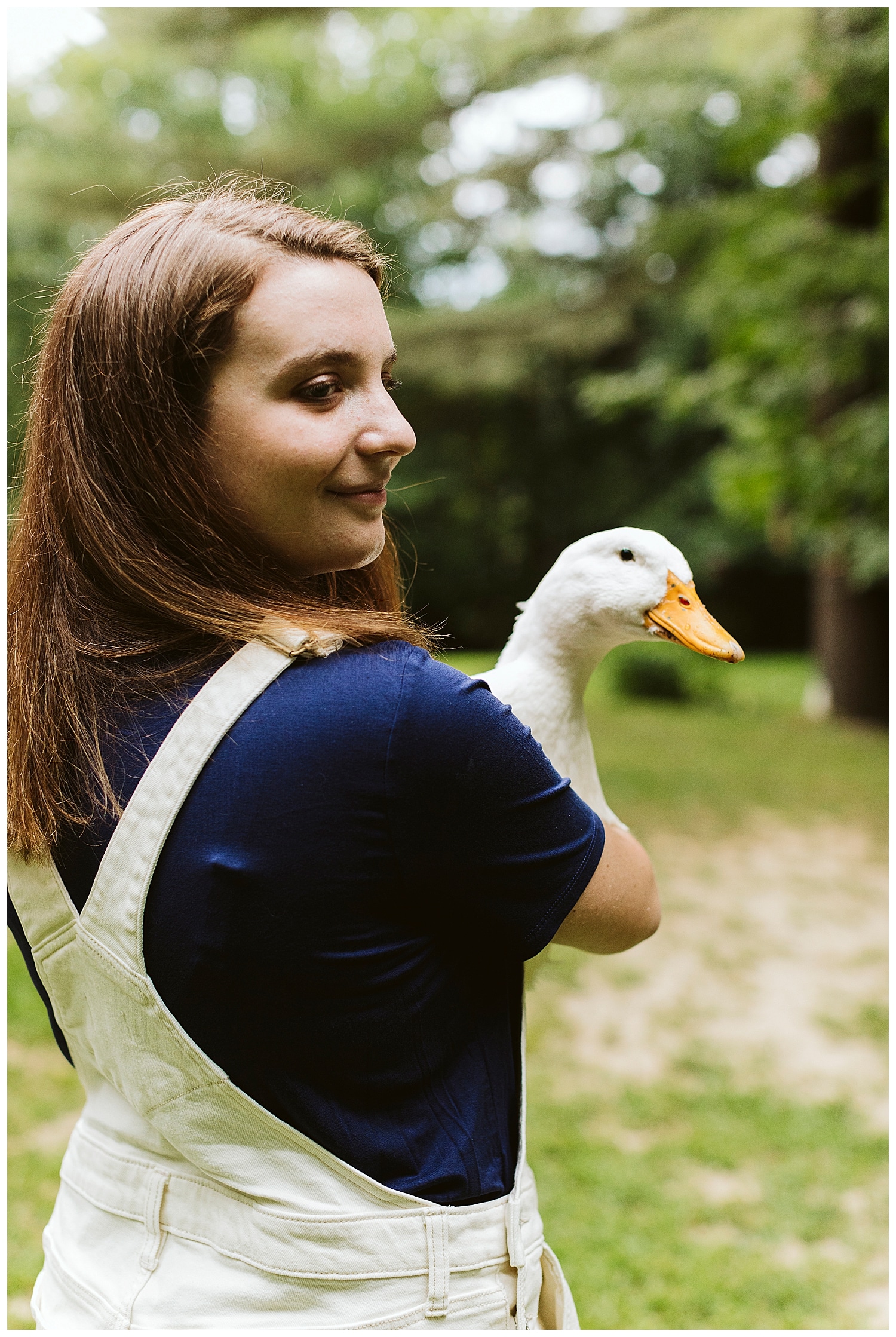 girl holding a duck during her Orrington, Maine senior portraits