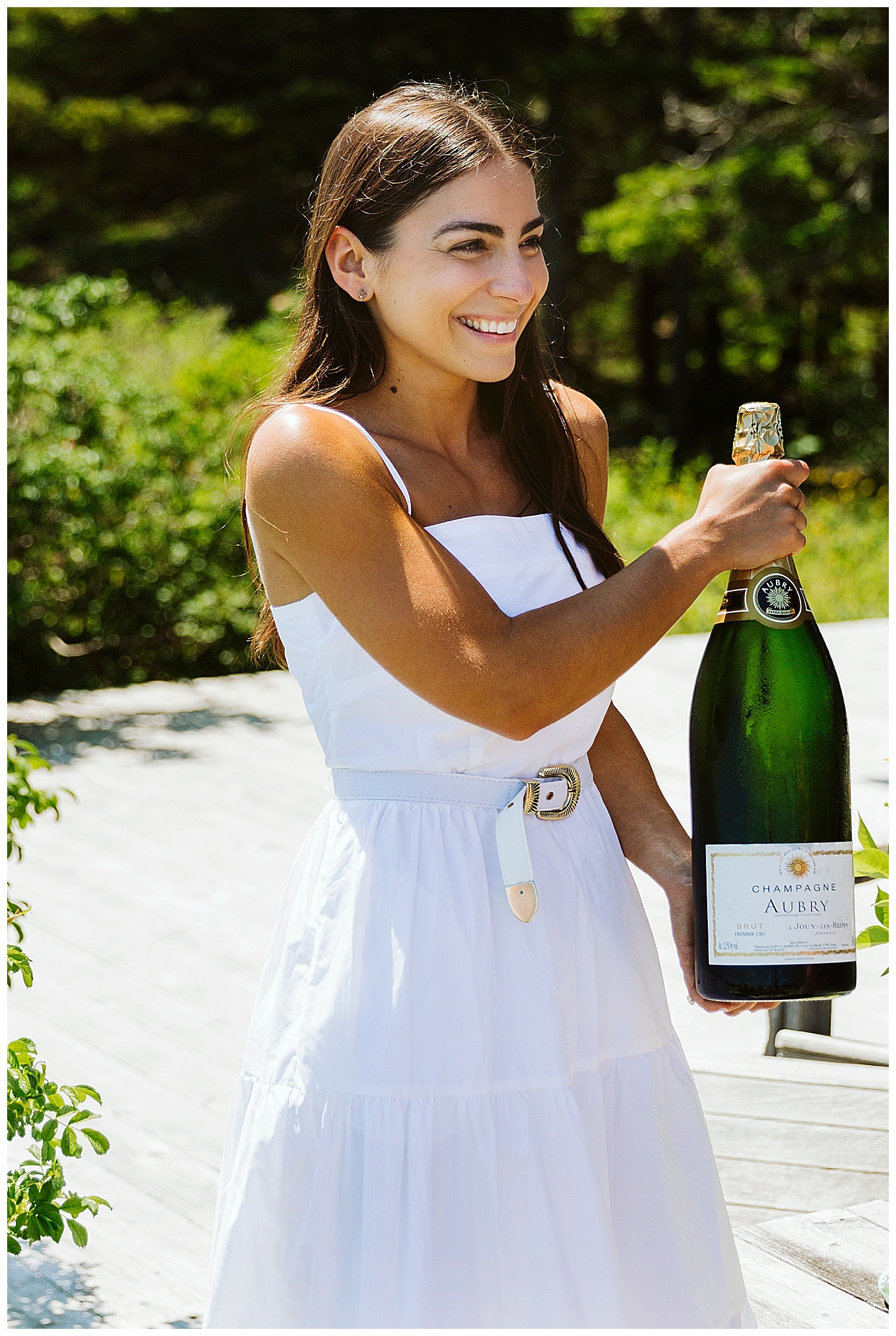 bride holding giant bottle of champagne