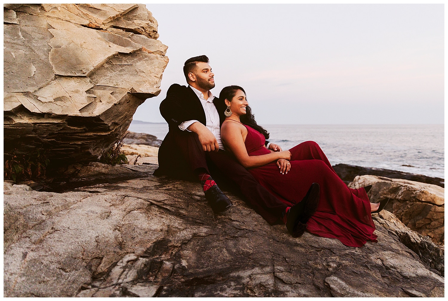 couple sitting on cliffs in Acadia