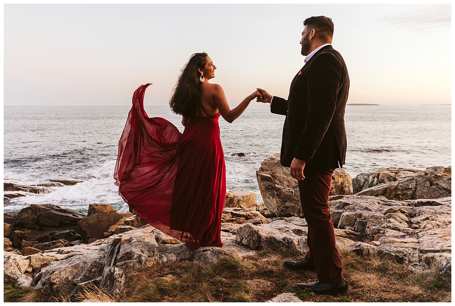 engaged couple with woman's red dress blowing in the wind