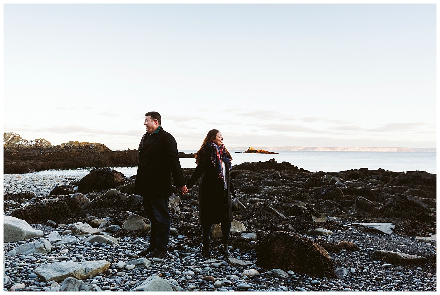 Couple holding hands on beach at Quoddy Head State Park in Lubec, Maine