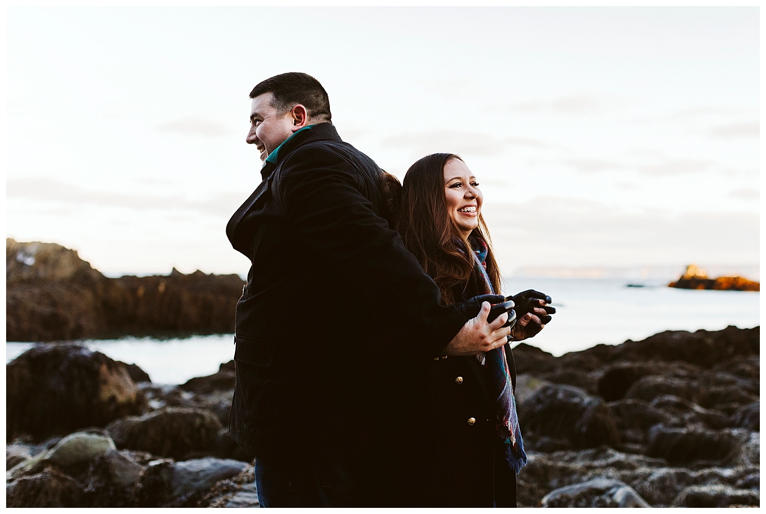 couple laughing at Quoddy Head State Park during engagement photos in Lubec, Maine