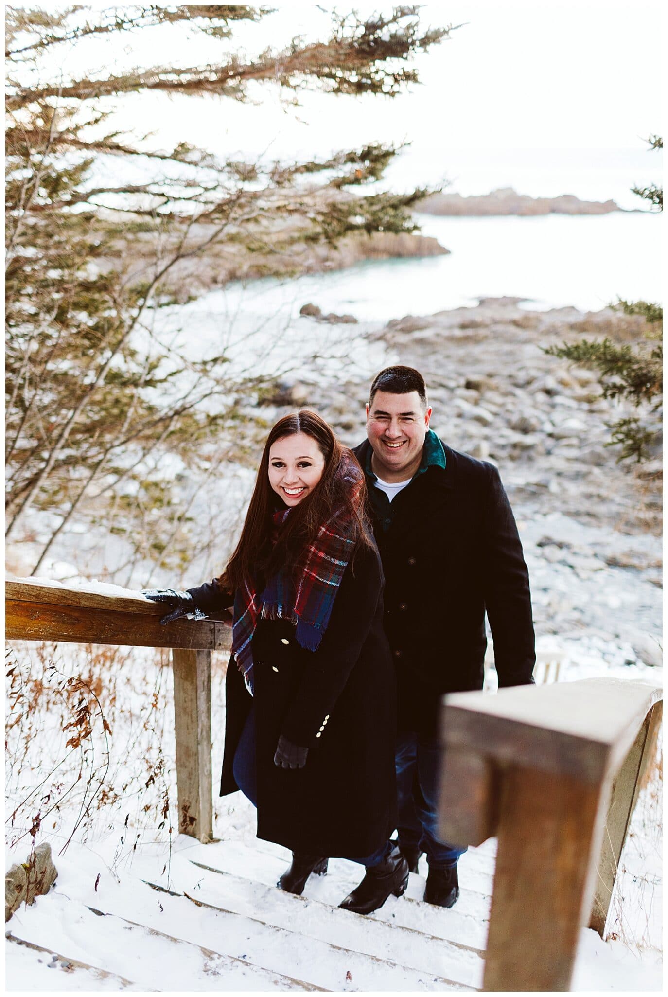 couple on stairs at Quoddy Head State Park during engagement photos in Lubec, Maine