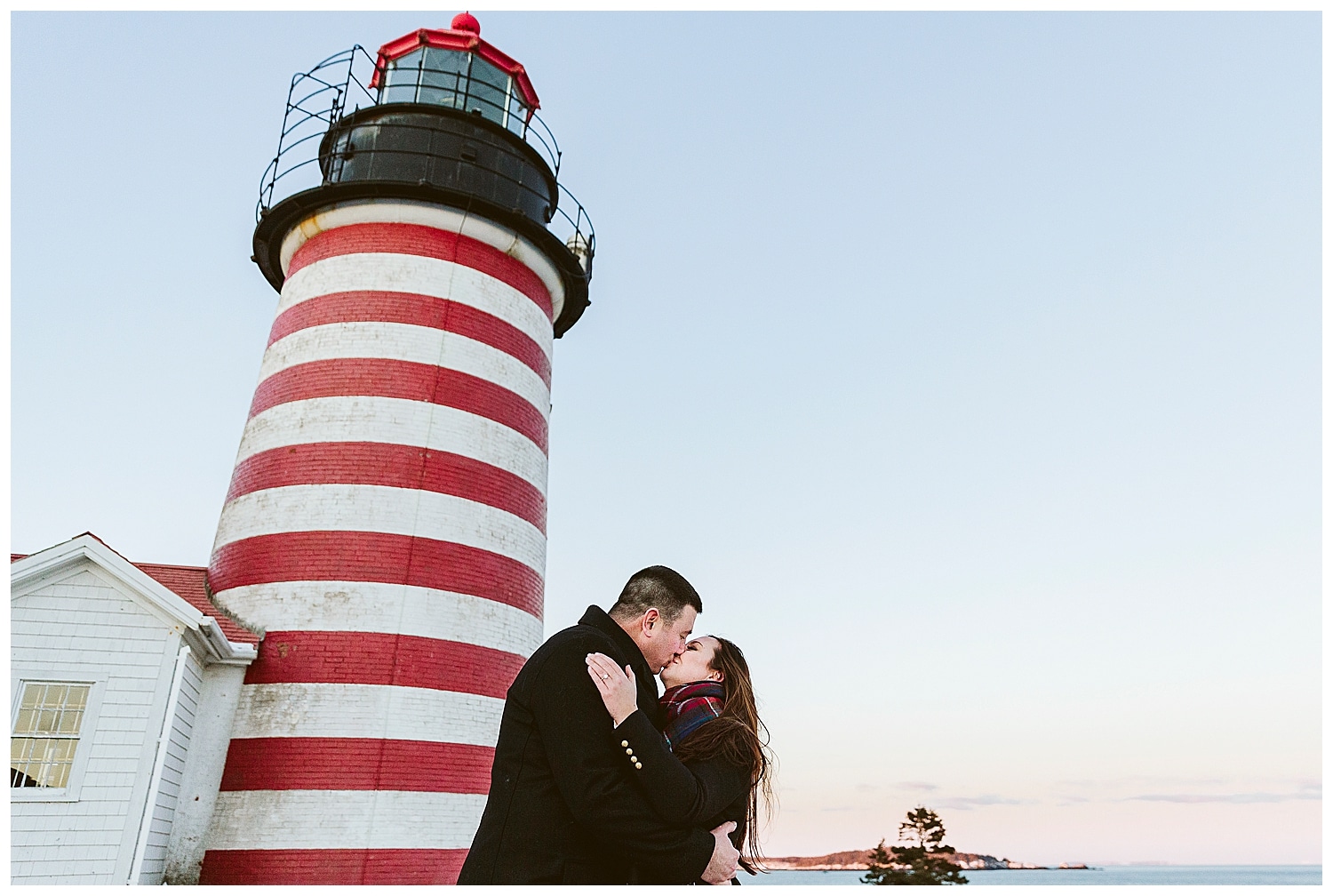 couple kissing in front of lighthouse