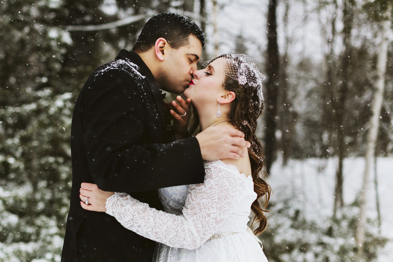 Groom kisses bride during winter wedding in Millinocket Maine