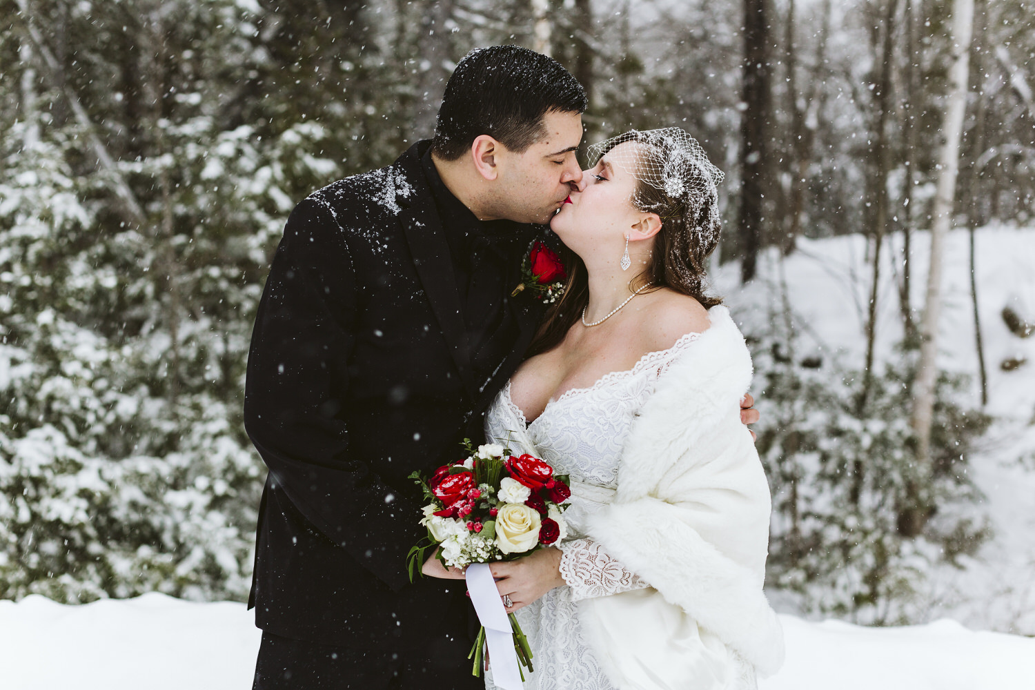 newlyweds kiss at winter wedding in Millinocket Maine