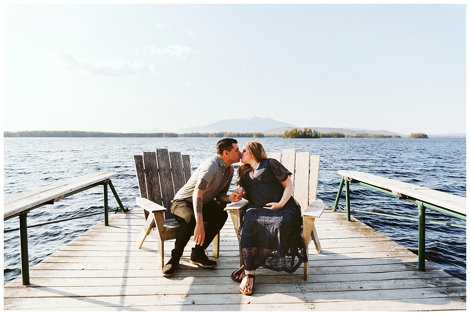 Expecting couple sitting on chairs in front of Mount Katahdin