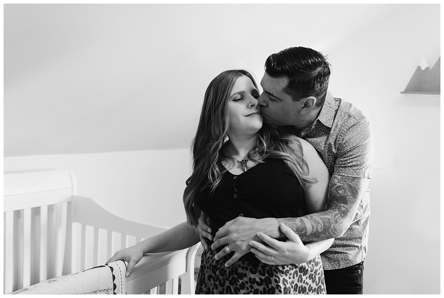 Expectant couple cuddling in baby's nursery