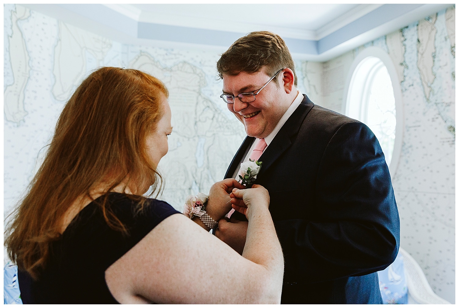 Mother of the groom attaches his boutonniere