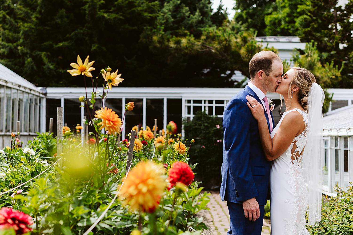 Bride and groom kissing next to flowers
