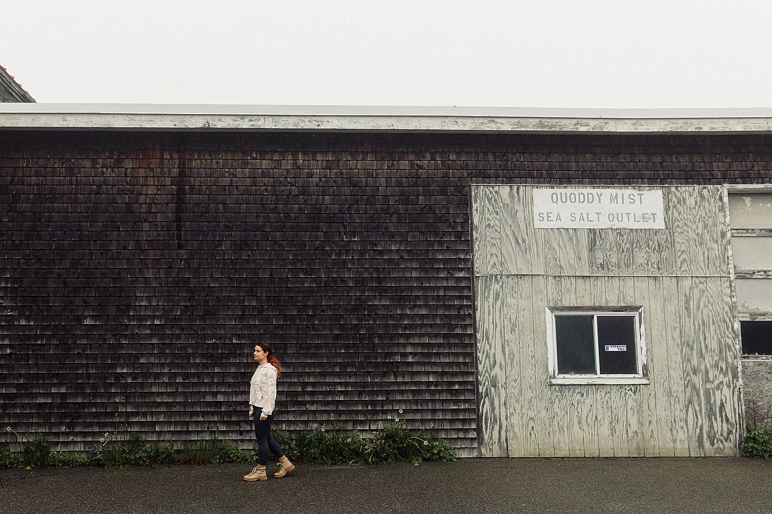 woman walking in front of old building in Lubec, Maine